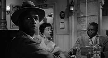 Movie still from “Anna Lucasta” (1958), directed by Arnold Laven – An older man and woman sitting at a table in a restaurant; Medium shot, Over the shoulder angle