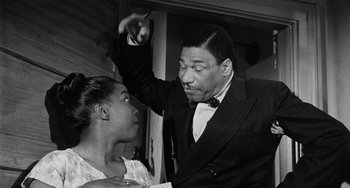 Movie still from “Anna Lucasta” (1958), directed by Arnold Laven – An old photo of a man and a young woman; Medium shot, Low angle