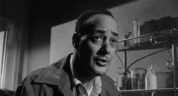 Movie still from “Anna Lucasta” (1958), directed by Arnold Laven – A black - and - white photo of a man in a lab coat; Close Up shot, Low angle