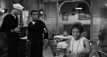 Movie still from “Anna Lucasta” (1958), directed by Arnold Laven – A black and white photo of a man and a woman in a restaurant; Medium shot, Over the shoulder angle