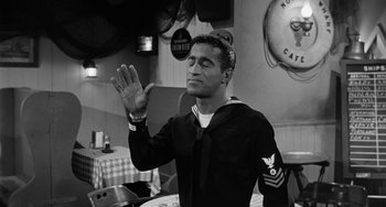 Movie still from “Anna Lucasta” (1958), directed by Arnold Laven – Black and white photograph of a sailor saluting in a restaurant; Medium shot, Low angle