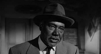 Movie still from “Anna Lucasta” (1958), directed by Arnold Laven – An older man wearing a suit and a hat; Close Up shot, Low angle