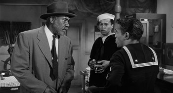 Movie still from “Anna Lucasta” (1958), directed by Arnold Laven – A black and white photo of three men talking; Medium shot, Over the shoulder angle