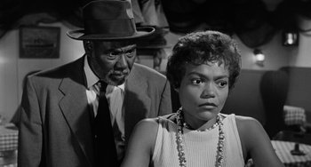 Movie still from “Anna Lucasta” (1958), directed by Arnold Laven – An older man and a younger woman in a black and white photo; Medium shot, Low angle