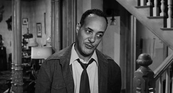 Movie still from “Anna Lucasta” (1958), directed by Arnold Laven – A black and white photo of a man in a suit and tie; Close Up shot, Low angle