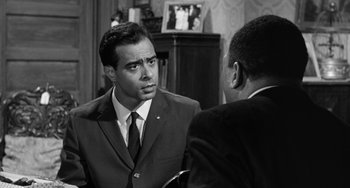 Movie still from “Anna Lucasta” (1958), directed by Arnold Laven – A man in a suit talking to another man in a suit and tie; Medium shot, Over the shoulder angle