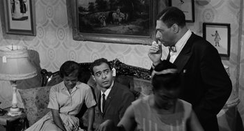 Movie still from “Anna Lucasta” (1958), directed by Arnold Laven – A group of men sitting on a couch in front of a painting; Medium shot, Low angle