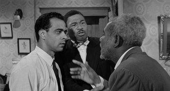 Movie still from “Anna Lucasta” (1958), directed by Arnold Laven – A group of men standing next to each other in a room; Medium shot, Low angle