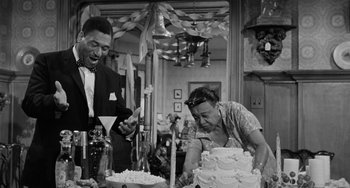 Movie still from “Anna Lucasta” (1958), directed by Arnold Laven – An old photo of a man and a woman cutting a cake; Medium shot, Low angle