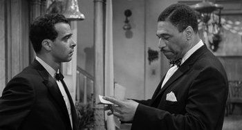 Movie still from “Anna Lucasta” (1958), directed by Arnold Laven – Two men in tuxedos looking at a piece of paper; Medium shot, Over the shoulder angle