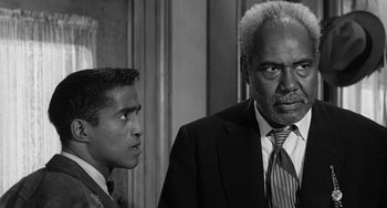 Movie still from “Anna Lucasta” (1958), directed by Arnold Laven – A man and a young man in suits looking at each other; Close Up shot, Over the shoulder angle