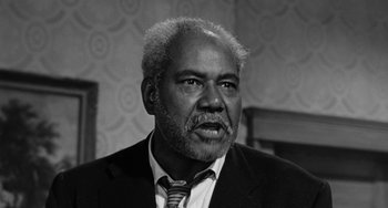 Movie still from “Anna Lucasta” (1958), directed by Arnold Laven – An older black man wearing a suit and tie; Close Up shot, Low angle