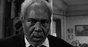 Movie still from “Anna Lucasta” (1958), directed by Arnold Laven – An older man wearing a suit and tie; Close Up shot, Low angle