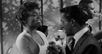 Movie still from “Anna Lucasta” (1958), directed by Arnold Laven – An older woman and a younger man are laughing together; Medium shot, Low angle