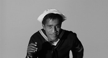 Movie still from “Anna Lucasta” (1958), directed by Arnold Laven – A man in a sailor's outfit is smiling for the camera; Close Up shot, High angle