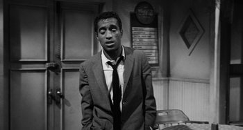 Movie still from “Anna Lucasta” (1958), directed by Arnold Laven – A black and white photo of a man in a suit and tie; Medium shot, High angle