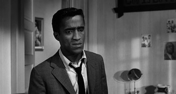 Movie still from “Anna Lucasta” (1958), directed by Arnold Laven – A black and white photo of a man wearing a suit and tie; Close Up shot, Over the shoulder angle