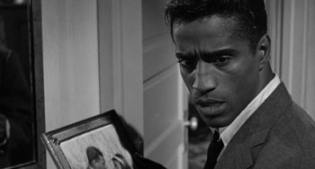 Movie still from “Anna Lucasta” (1958), directed by Arnold Laven – A black and white photo of a man looking at a picture; Close Up shot, Over the shoulder angle