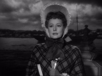 Movie still from “Anna and the King of Siam” (1946), directed by John Cromwell – An old photo of a woman wearing a plaid coat and a hat; Close Up shot, Low angle