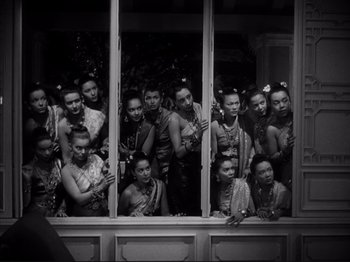 Movie still from “Anna and the King of Siam” (1946), directed by John Cromwell – A black and white photo of a group of people standing by a window; Wide shot, High angle