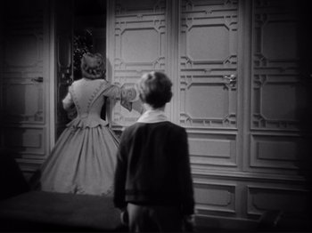 Movie still from “Anna and the King of Siam” (1946), directed by John Cromwell – A little girl and a boy are looking in a mirror; Medium shot, Over the shoulder angle