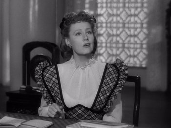 Movie still from “Anna and the King of Siam” (1946), directed by John Cromwell – A woman sitting at a dining room table looking to her left; Medium shot, Low angle