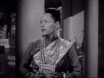 Movie still from “Anna and the King of Siam” (1946), directed by John Cromwell – An old photo of an asian woman holding a book; Medium shot, Low angle