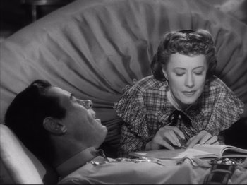 Movie still from “Anna and the King of Siam” (1946), directed by John Cromwell – A man and a woman are lying in a bed reading; Medium shot, Overhead angle