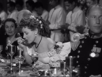Movie still from “Anna and the King of Siam” (1946), directed by John Cromwell – A woman in a white dress is eating at a table; Medium shot, Over the shoulder angle