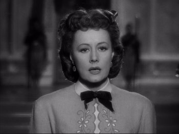 Movie still from “Anna and the King of Siam” (1946), directed by John Cromwell – An old black and white photo of a woman with a bow tie; Close Up shot, Low angle