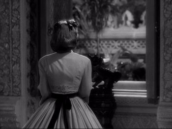 Movie still from “Anna and the King of Siam” (1946), directed by John Cromwell – A woman standing in front of a window with her back turned; Medium shot, Over the shoulder angle