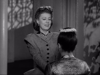 Movie still from “Anna and the King of Siam” (1946), directed by John Cromwell – An old photo of a woman talking to a young girl; Medium shot, Over the shoulder angle