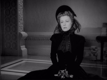 Movie still from “Anna and the King of Siam” (1946), directed by John Cromwell – A black and white photo of a woman in a black dress; Medium shot, Low angle