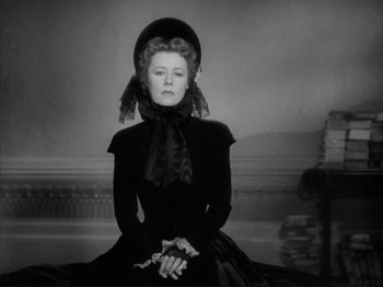 Movie still from “Anna and the King of Siam” (1946), directed by John Cromwell – An old photo of a woman wearing a black dress and a hat; Medium shot, Low angle