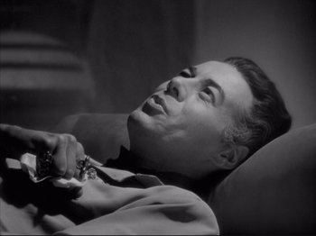 Movie still from “Anna and the King of Siam” (1946), directed by John Cromwell – A black - and - white photo of a man holding a pair of scissors; Close Up shot, High angle