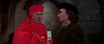 Movie still from “Anne of the Thousand Days” (1969), directed by Charles Jarrott – A man in a red robe and a man in a black suit; Medium shot, Over the shoulder angle