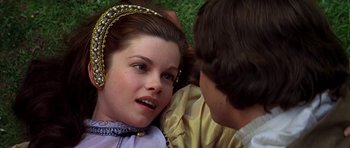Movie still from “Anne of the Thousand Days” (1969), directed by Charles Jarrott – A young woman wearing a headdress is lying on the grass; Close Up shot, Overhead angle