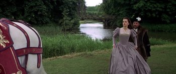 Movie still from “Anne of the Thousand Days” (1969), directed by Charles Jarrott – A woman dressed in medieval clothing standing in front of a body of water; Wide shot, Low angle