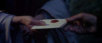 Movie still from “Anne of the Thousand Days” (1969), directed by Charles Jarrott – A person holding a piece of paper with a red substance on it; Extreme Close Up shot, High angle