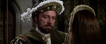 Movie still from “Anne of the Thousand Days” (1969), directed by Charles Jarrott – A person wearing a suit and a hat; Close Up shot, Over the shoulder angle