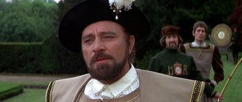 Movie still from “Anne of the Thousand Days” (1969), directed by Charles Jarrott – A man with a beard wearing a hat; Close Up shot, Over the shoulder angle