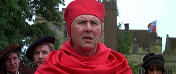 Movie still from “Anne of the Thousand Days” (1969), directed by Charles Jarrott – A man in a red robe and a red hat; Close Up shot, Over the shoulder angle