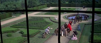 Movie still from “Anne of the Thousand Days” (1969), directed by Charles Jarrott – A group of people standing around a garden; Extreme Wide shot, High angle