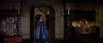Movie still from “Anne of the Thousand Days” (1969), directed by Charles Jarrott – A woman dressed in a blue dress standing in a doorway; Wide shot, High angle