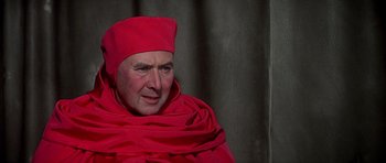 Movie still from “Anne of the Thousand Days” (1969), directed by Charles Jarrott – A man wearing a red hat and a red robe; Close Up shot, High angle