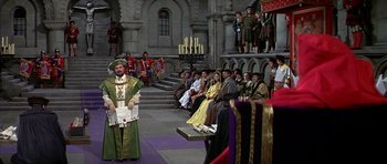 Movie still from “Anne of the Thousand Days” (1969), directed by Charles Jarrott – A group of people sitting on steps in front of an audience; Wide shot, High angle