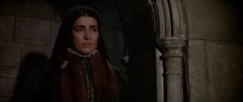 Movie still from “Anne of the Thousand Days” (1969), directed by Charles Jarrott – A woman in a medieval dress standing next to a pillar; Close Up shot, Low angle