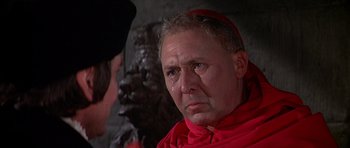 Movie still from “Anne of the Thousand Days” (1969), directed by Charles Jarrott – An older man in a red robe crying; Close Up shot, Over the shoulder angle