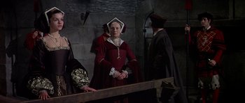 Movie still from “Anne of the Thousand Days” (1969), directed by Charles Jarrott – A woman in a red dress standing in front of a mirror; Medium shot, Over the shoulder angle