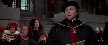 Movie still from “Anne of the Thousand Days” (1969), directed by Charles Jarrott – A man dressed as a medieval knight holding a sword; Medium shot, Over the shoulder angle